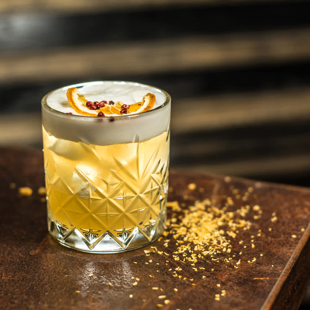 A whiskey sour drink on a table