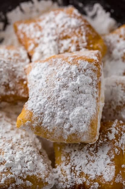 A pile of New Orleans-style beignets dusted with powdered sugar
