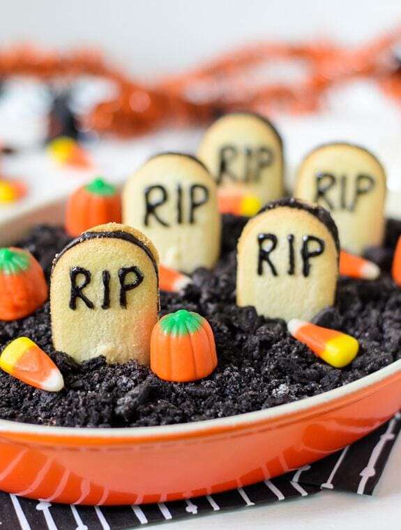 Graveyard chocolate cheesecake dip with headstone cookies, candy corn and candy pumpkins
