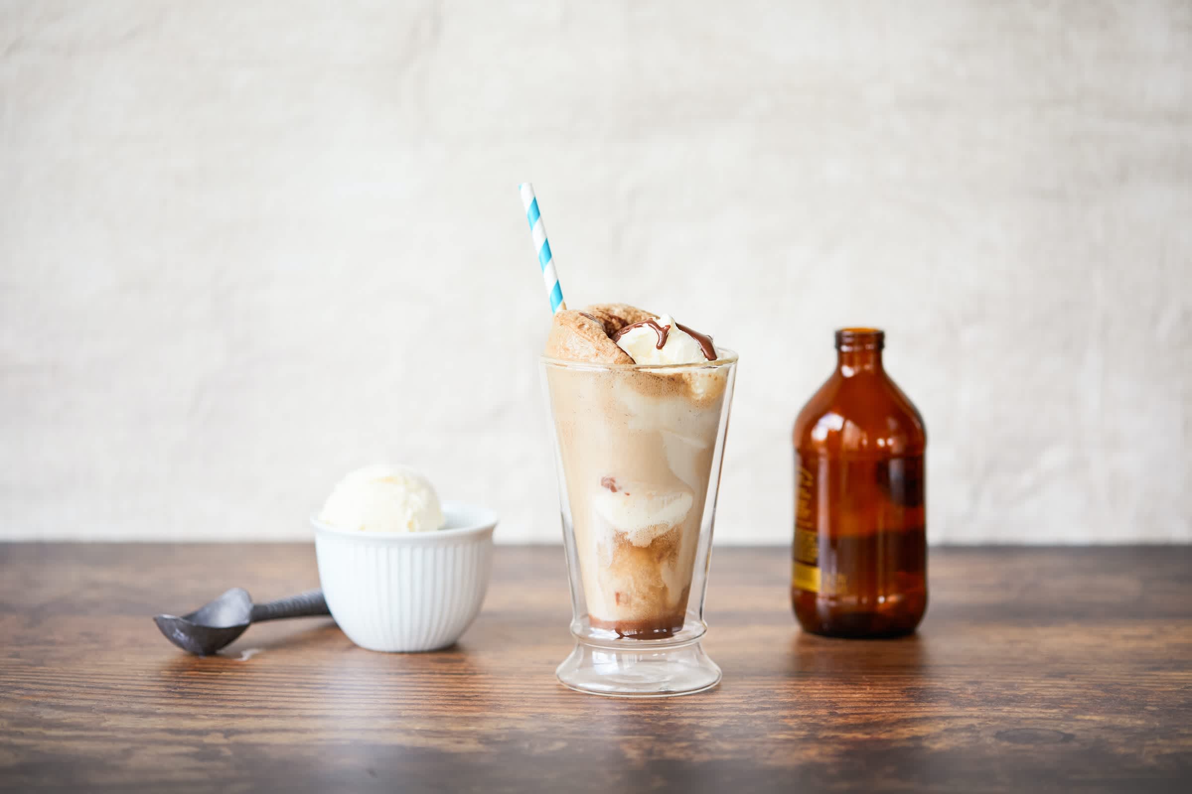 Little bottle of root beer next to a floating vanilla ice cream