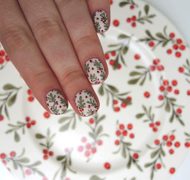 Christmas plant nail art with green leaves & red berries on white nails  