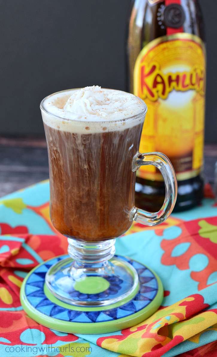 A tequila and Kahlua cocktail in tall, clear, coffee glass; bottle of Kahlua