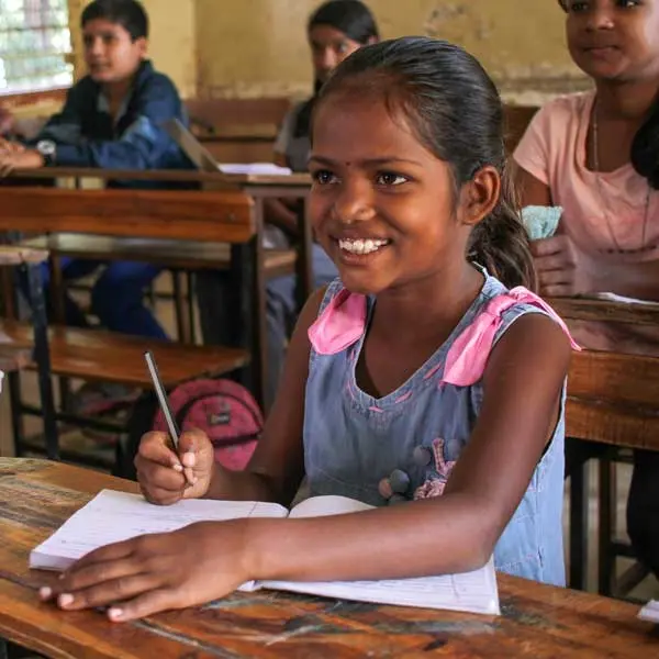 menina indiana sorrindo na sala de aula