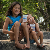 crianças bebendo água purificada P&G e sorrindo