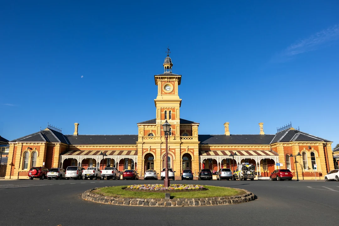 Historic train station with a clock tower under blue sky
