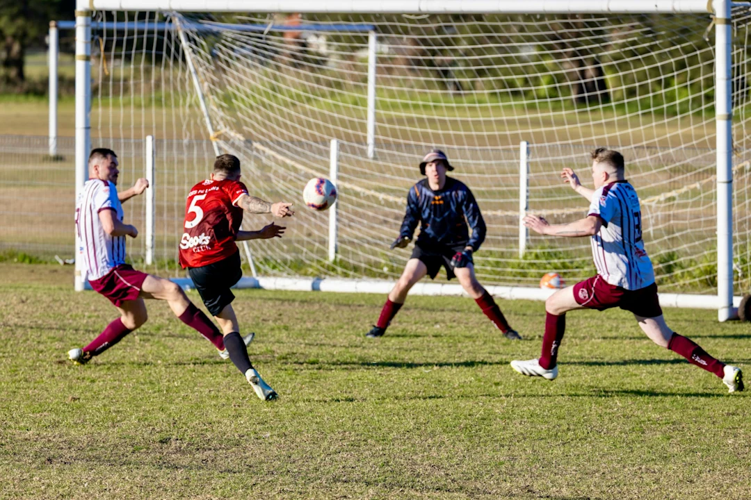 Soccer players competing for the ball near the goal.