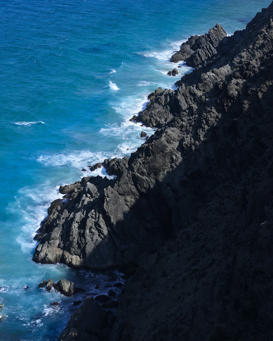 A man riding a surfboard on top of a cliff near the ocean
