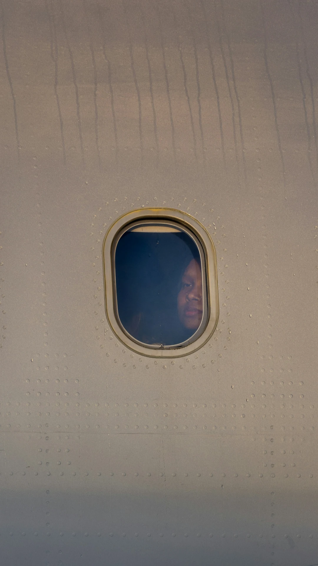 A person looks out an airplane window.