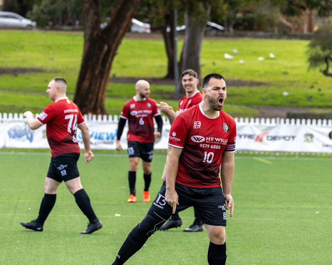 Men in red soccer uniforms playing on a field