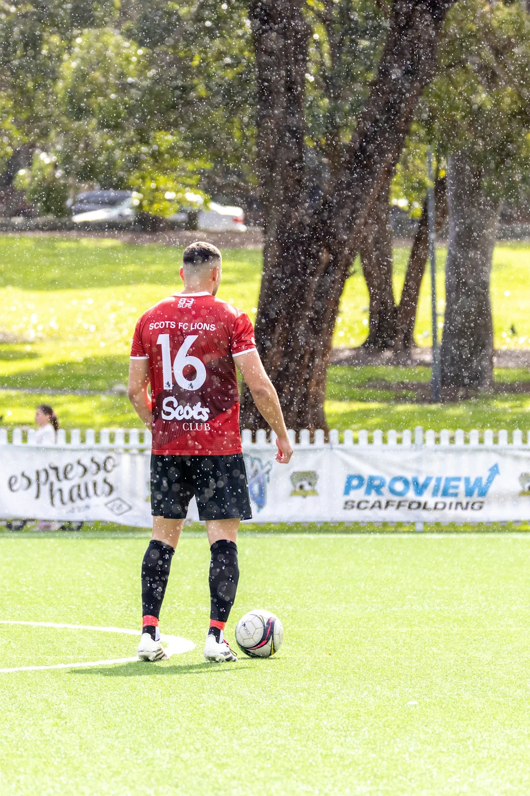 Soccer player standing on field in rain