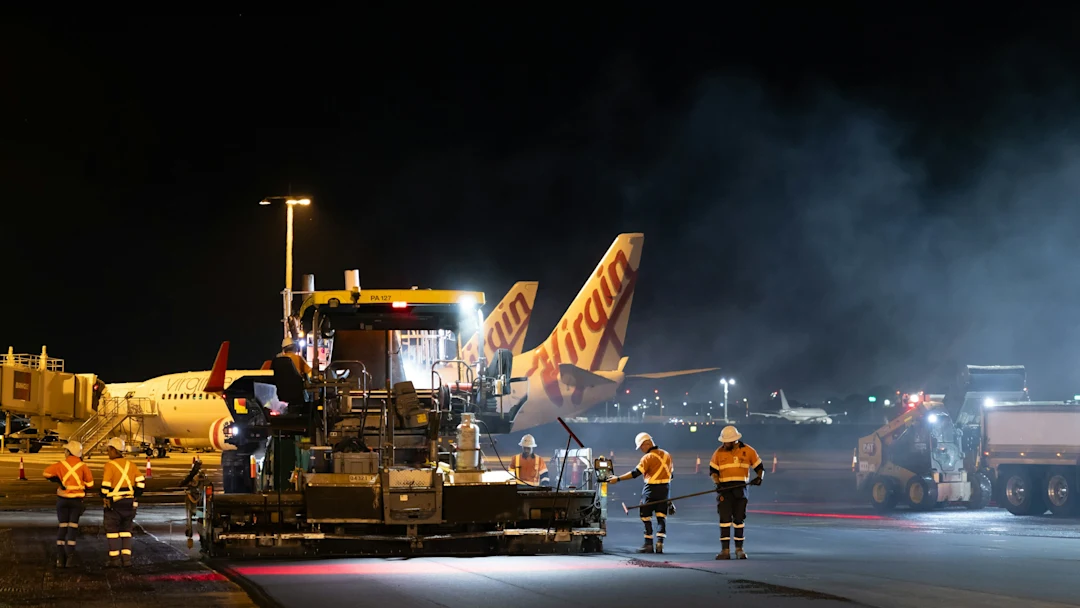 Airport tarmac crew working at night with airplanes
