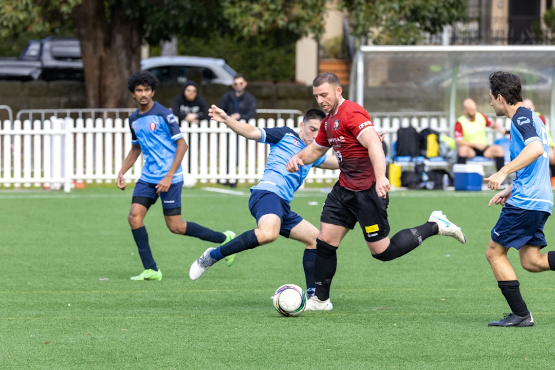 Soccer players competing for the ball on a field.