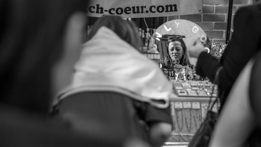 Woman looking in mirror at jewelry display