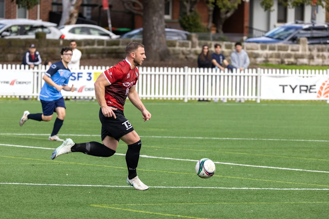 Soccer player dribbling ball on green field