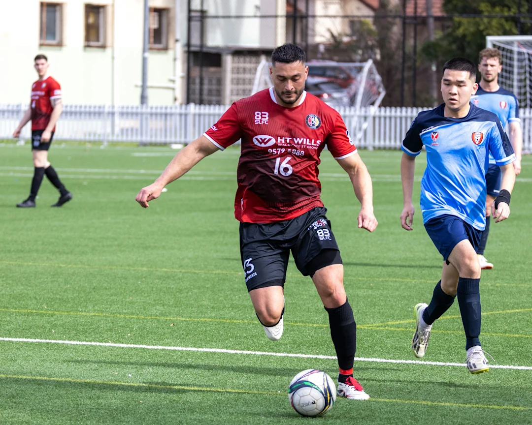 Soccer player dribbling ball on green field