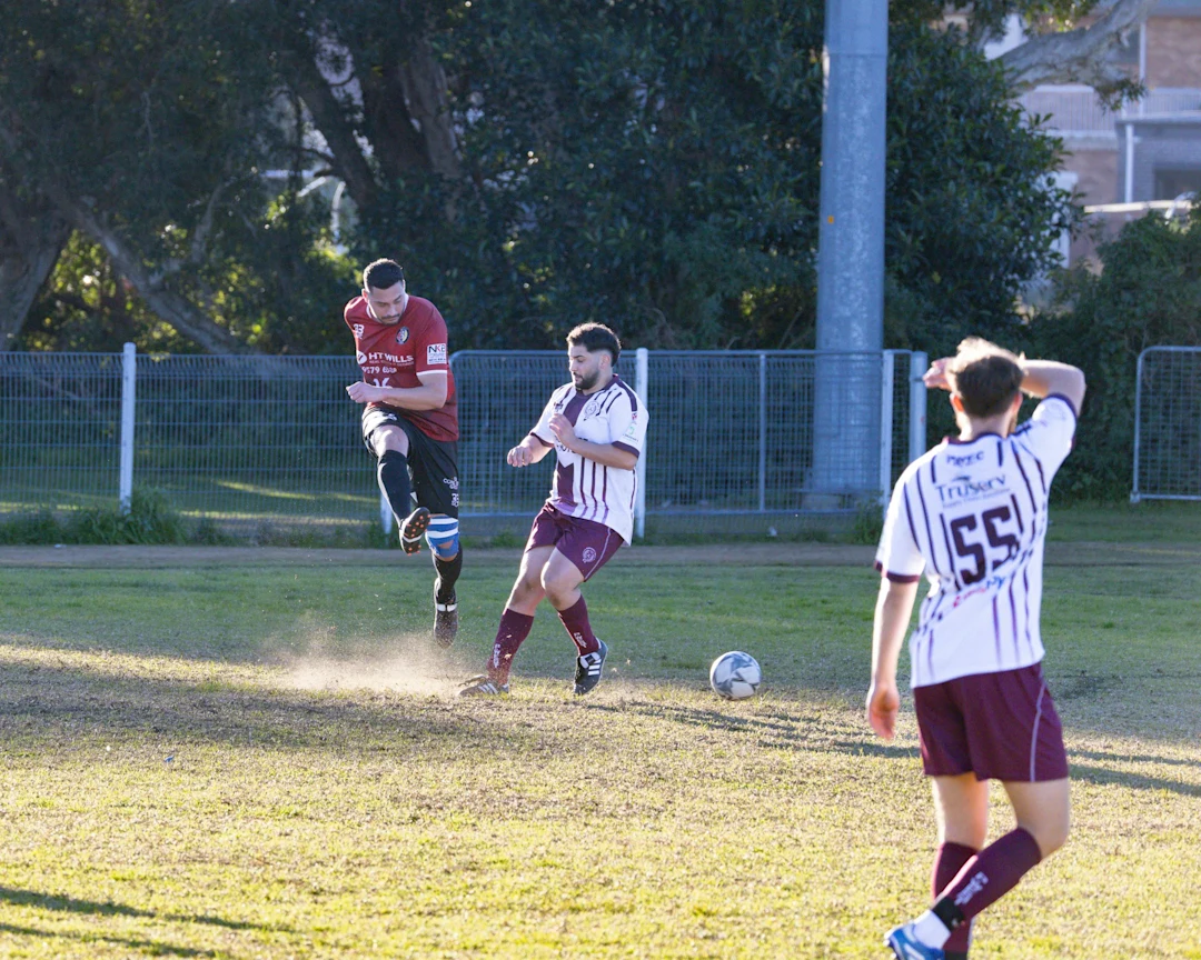 Soccer players compete for the ball on a field.