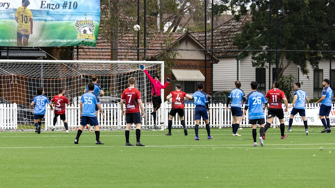 Soccer players competing for the ball near the goal.