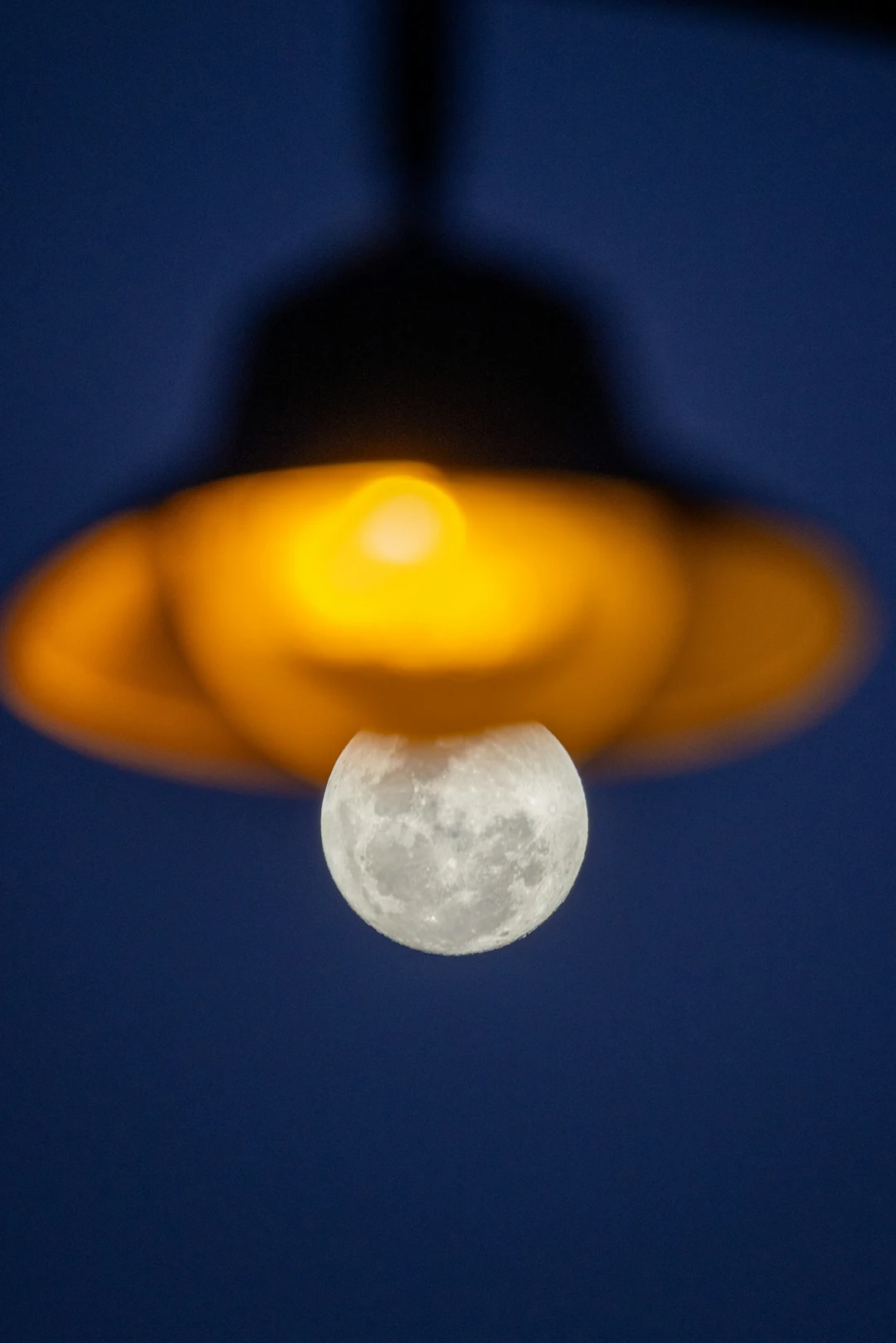 Full moon centered beneath a glowing lamp