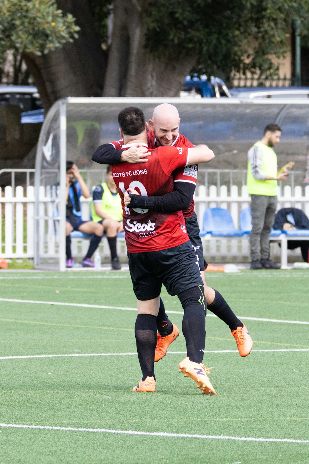Two soccer players celebrating on a field.