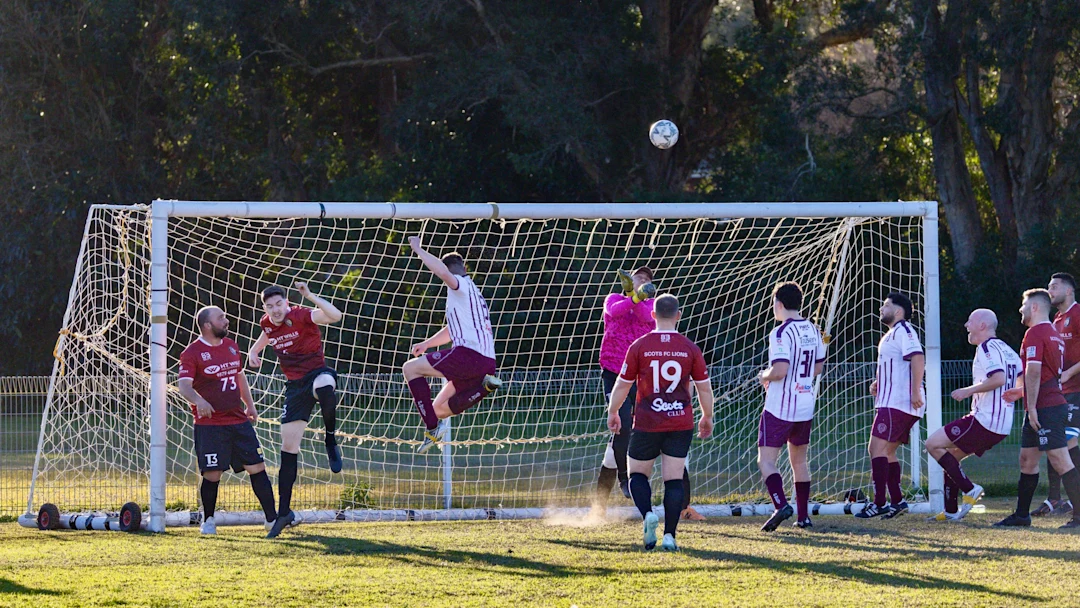 Soccer players jumping for ball near goal