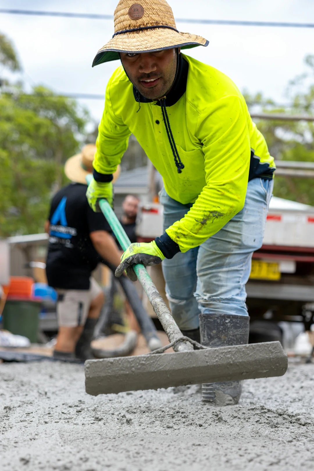 Man levels wet cement with a concrete float.