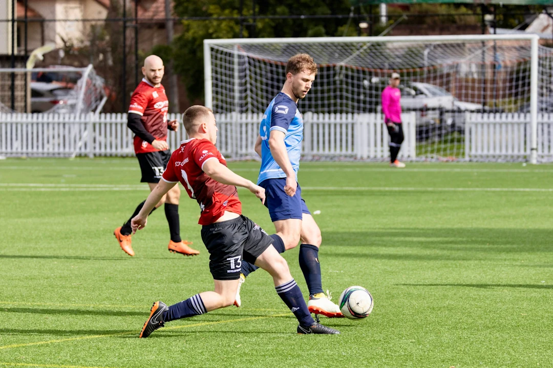 Soccer players competing for the ball on a field.