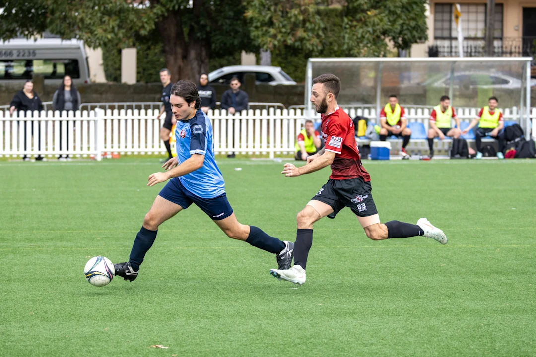 Two soccer players competing for the ball on field.