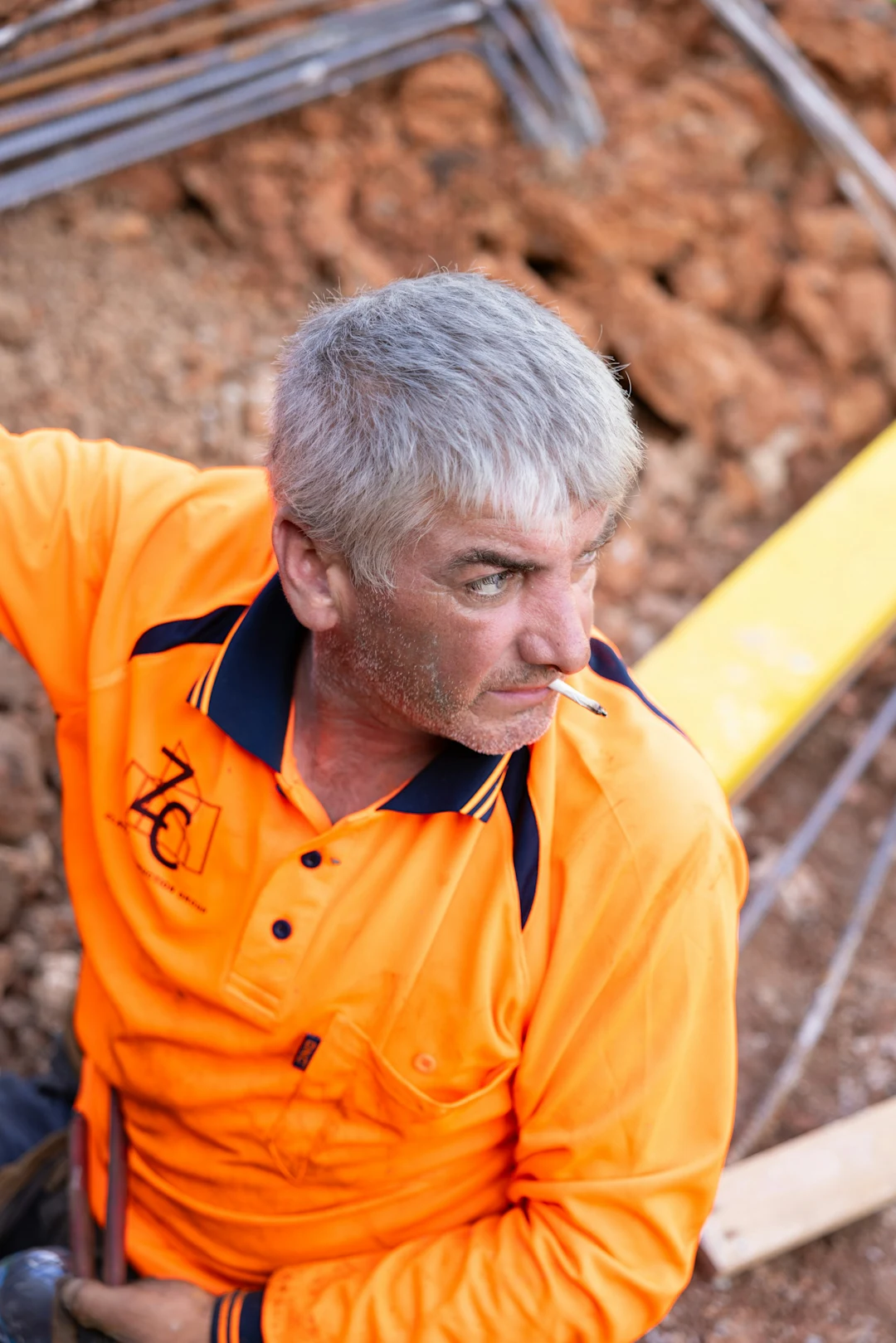 A construction worker pauses for a smoke break.