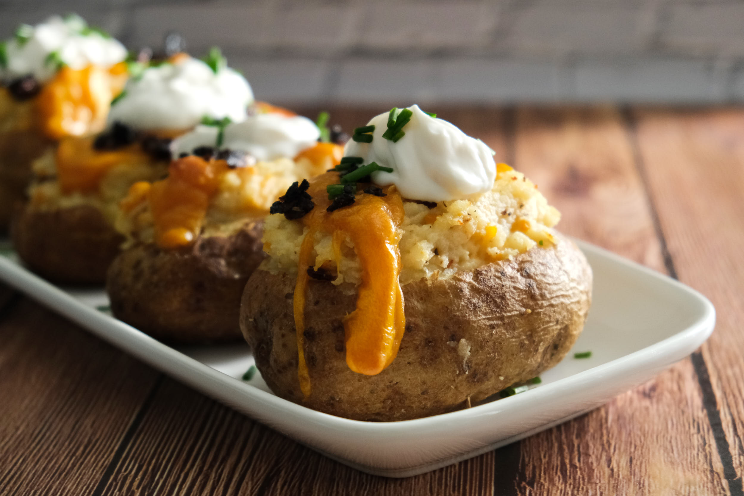 https://images.ctfassets.net/092wi7ilt2cf/7zO522f9DcHwIUDSI37xKo/5dffb675a916c69ce7aad1b240664bf2/close-up-loaded-baked-potato-with-dripping-cheese.jpg