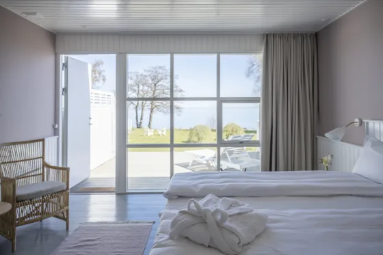 Minimalistisk skandinavisk værelse med udsigt over havet