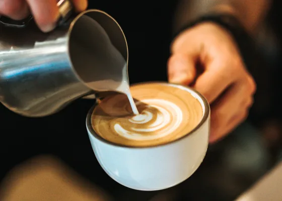 A barista prepares a cappuccino