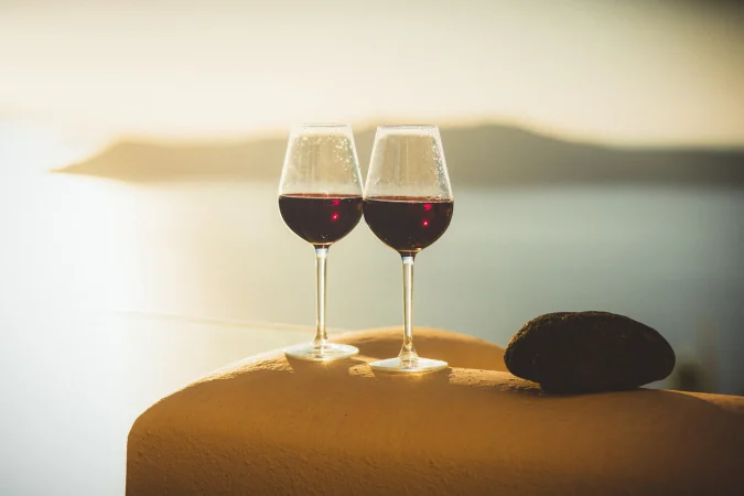 To glas rødvin med havet i baggrunden