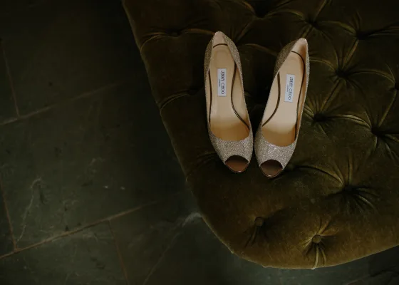 Ett par glittriga Jimmy Choo-skor på en grön sammetssoffa