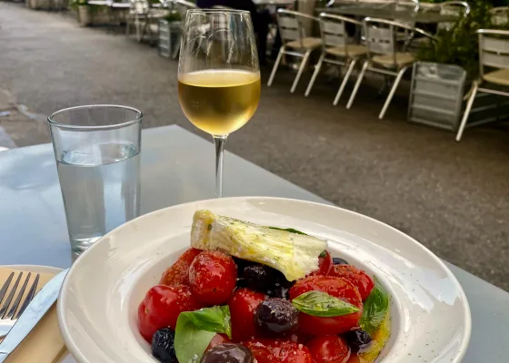 A rustic tomato salad with a glass of white wine