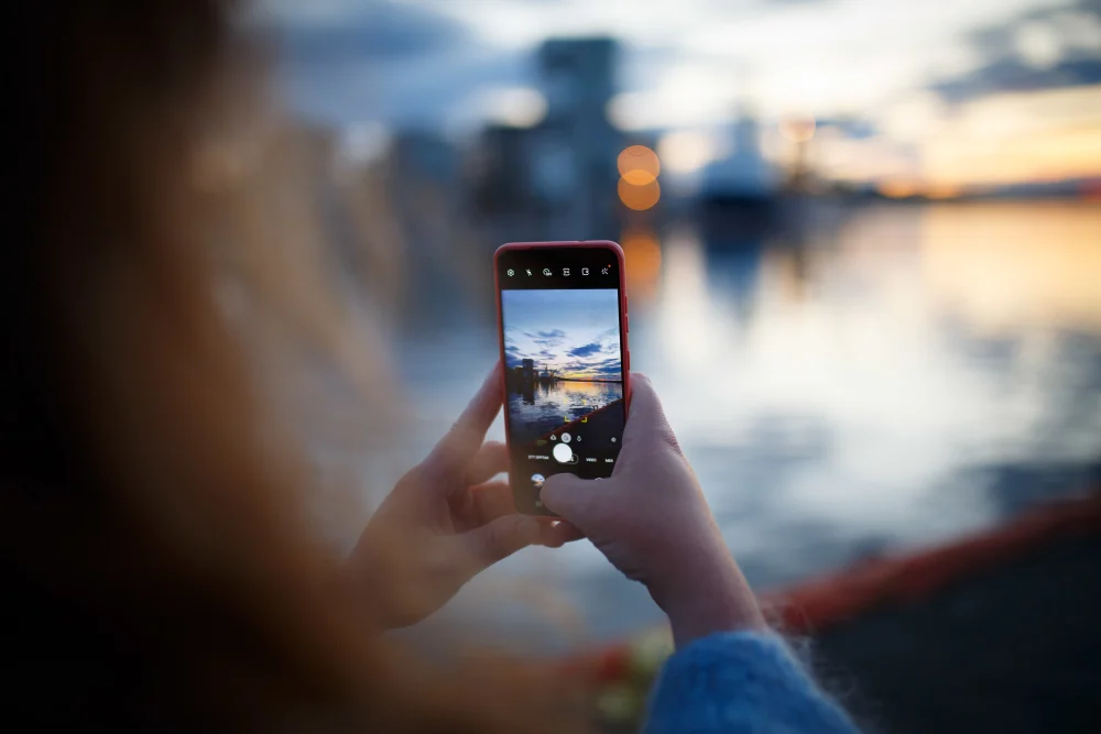 A woman photographing the sunset in Tønsberg