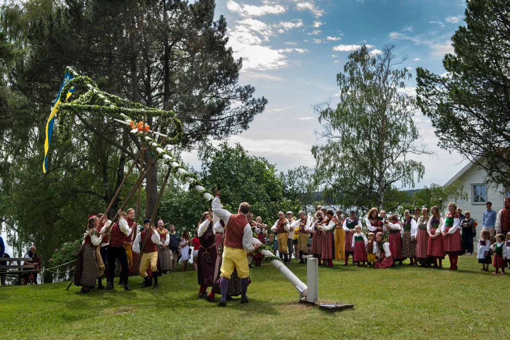 Folk som feirer midtsommer i Sverige kledd i tradisjonelle folkedrakter