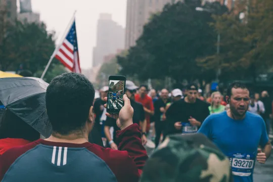En man som tar ett foto av deltagare i New York City Marathon