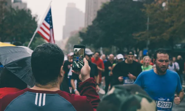 En mand, der tager et billede af deltagere i New York City Marathon