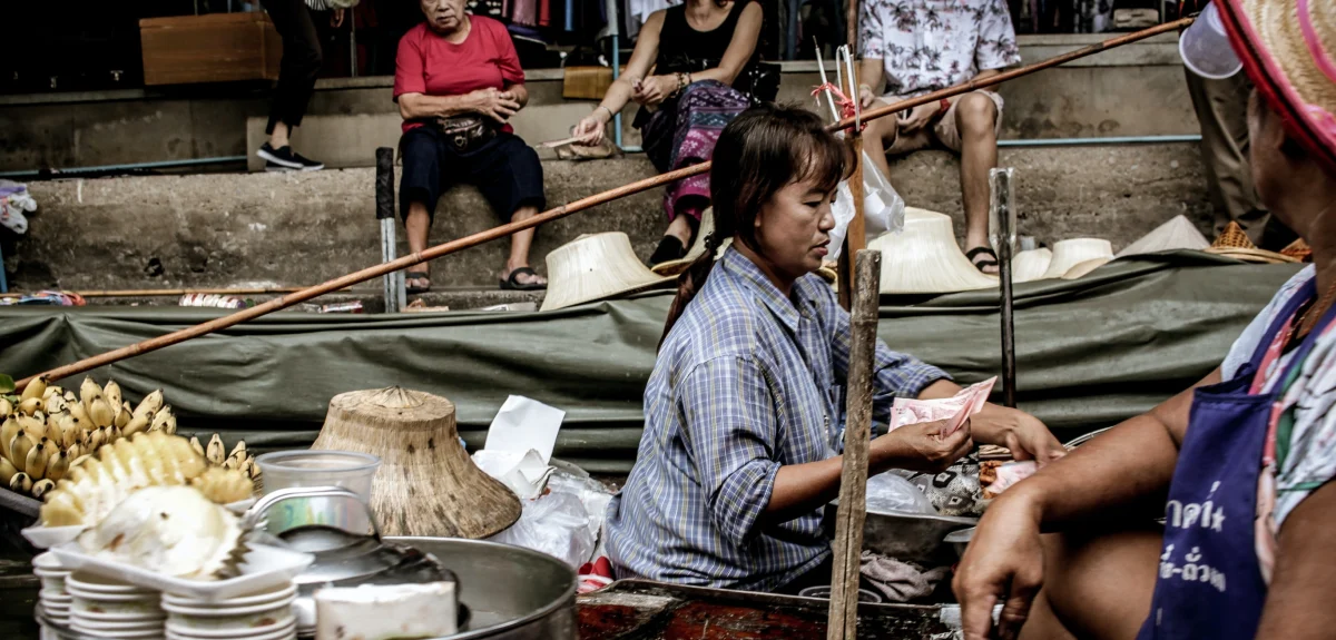 En kvinna som jobbar på en marknad i Bangkok