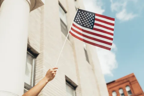 Någon håller upp den amerikanska flaggan i luften.