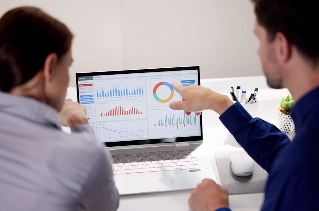 two people analyzing a supply chain risk mapping dashboard on a laptop