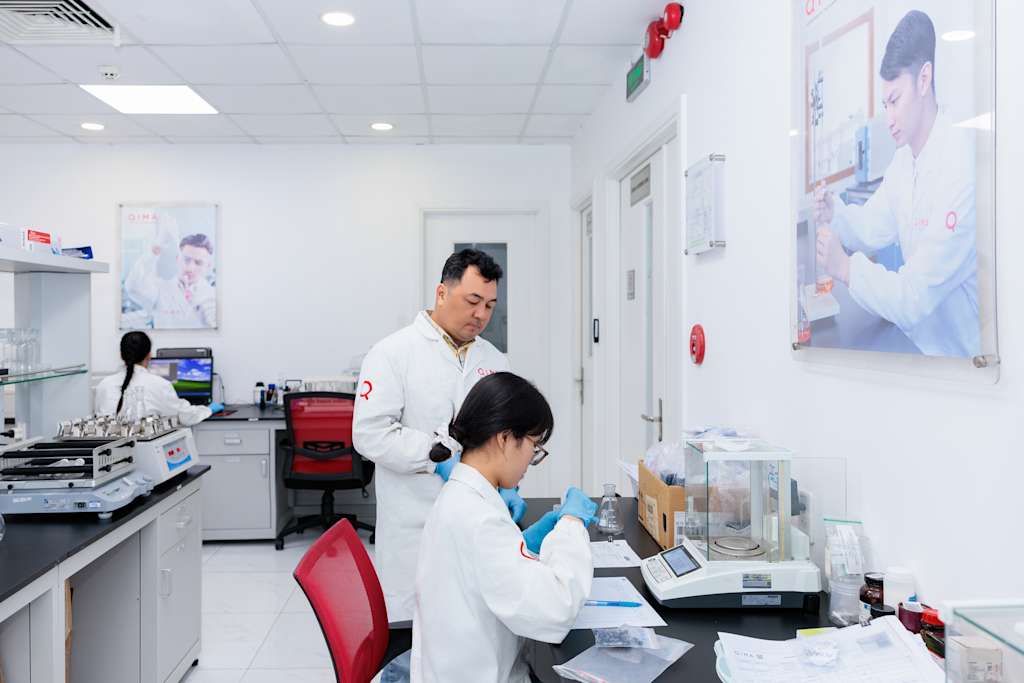 QIMA lab technicians perform chemical and physical testing at an accredited laboratory, supporting compliance programs for consumer products across global markets.