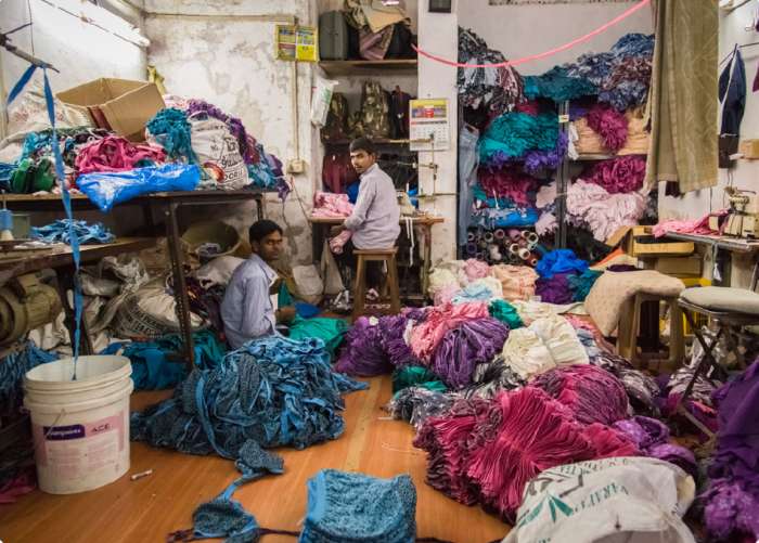 Apparel industry workers with fabric – ESG risk management