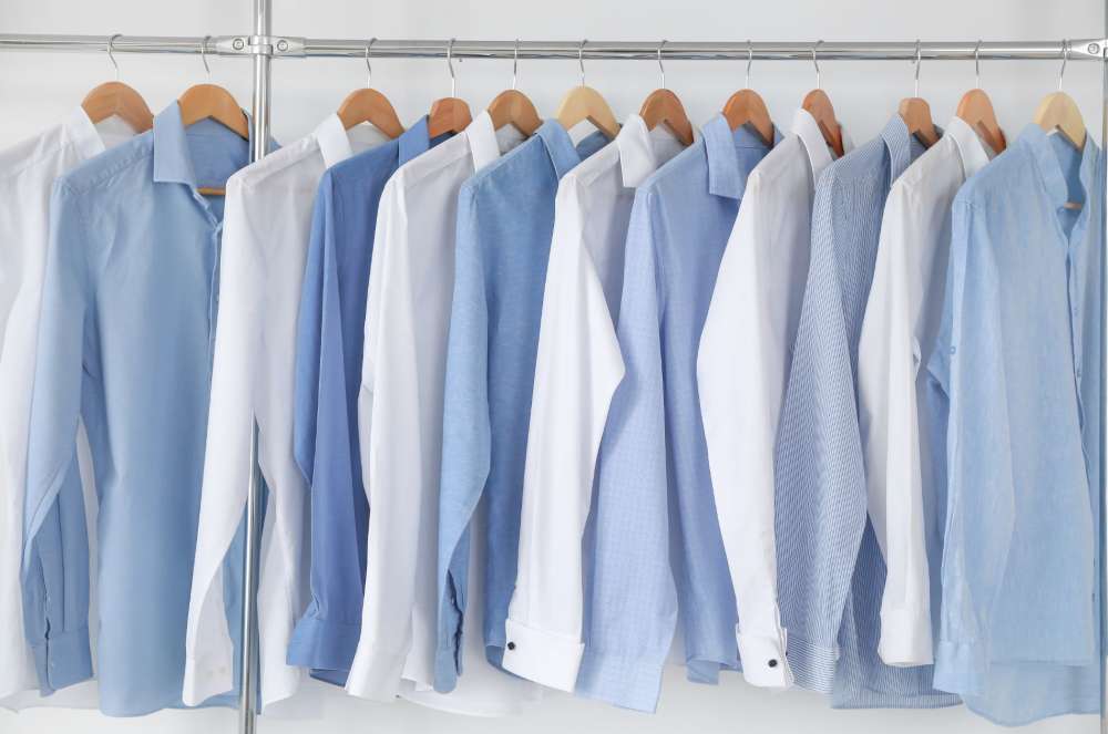 A rack of white and blue non-iron shirts hanging on a hanger, showcasing a variety of colors and styles.