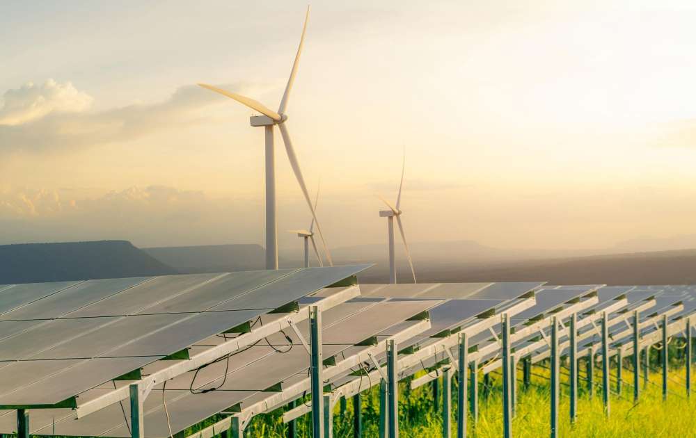 a row of solar panels and wind turbines