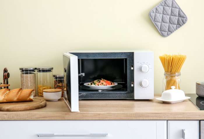 A microwave oven on a kitchen counter top with food in it