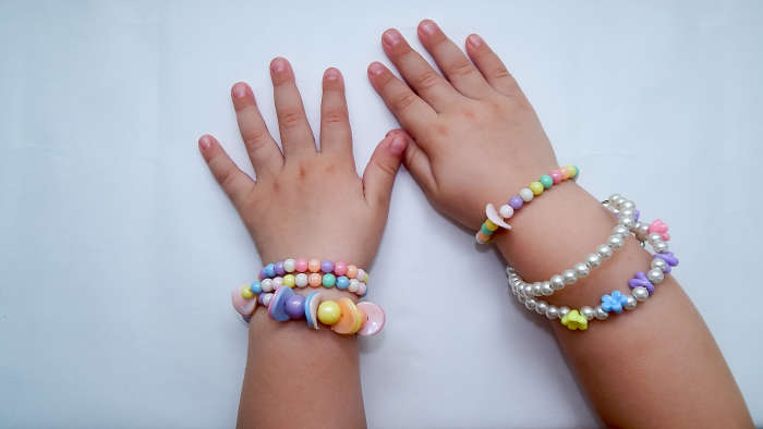 Child’s hands with bracelets – CPSIA jewelry - astm f2923