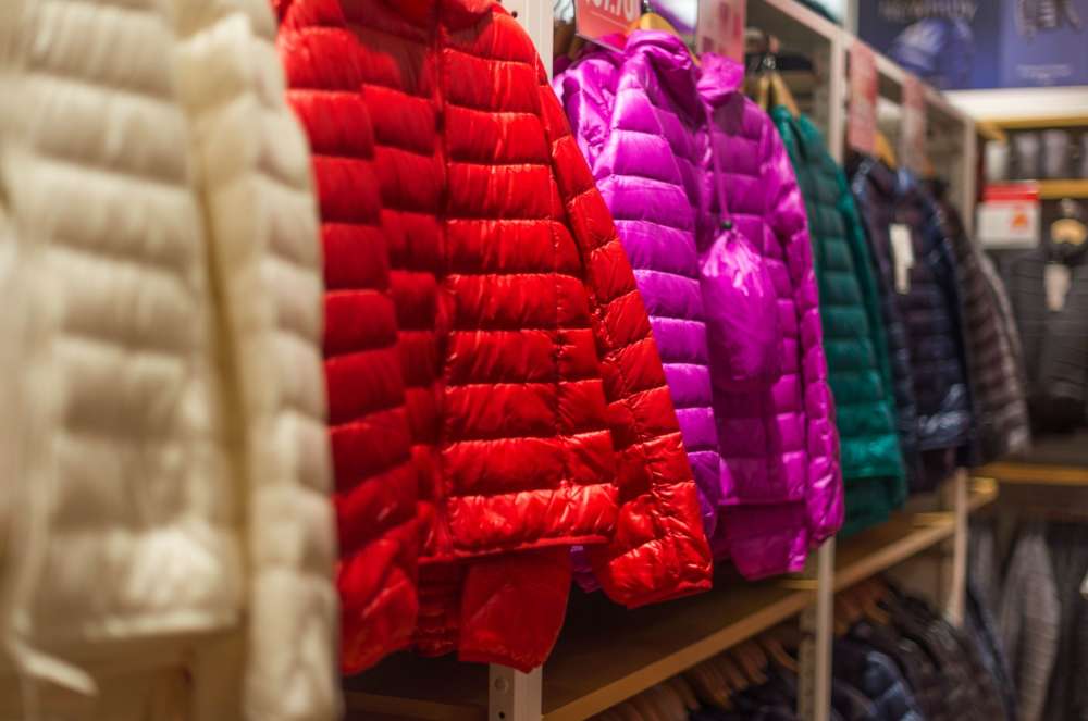 a group of colorful coats on a shelf
