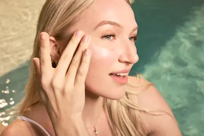 Woman adding sunscreen to her cheek. 