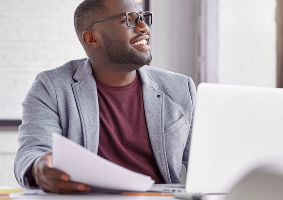 Young man smiling sitting at laptop